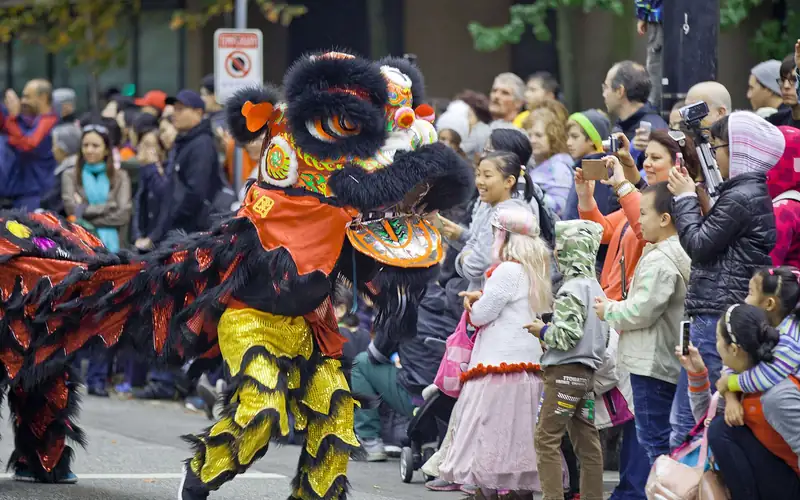 Costumed performers and kids at a city Halloween parade